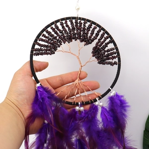 Detail of Tree of Life dream catcher with copper wire, red stones, and purple feathers
