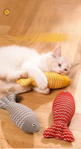 Detail von bunten Fisch-Katzenspielzeugen aus Leinen mit spielender Katze auf Holz