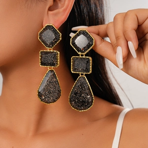 Boucles d'oreilles pendantes géométriques en résine noire et paillettes dorées style rétro