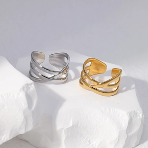Detailed view of layered gold and silver stainless steel rings on a stone base