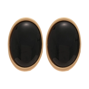 Boucles d'oreilles ovales en résine noire avec cadre doré sur fond blanc pur