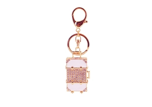 Close-up of sparkling pink rhinestone luggage suitcase keychain with gold finish lobster clasp