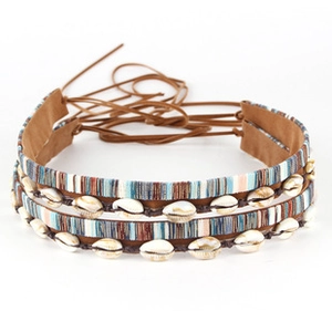 Detail of bohemian woven choker featuring natural seashells and striped fabric ties