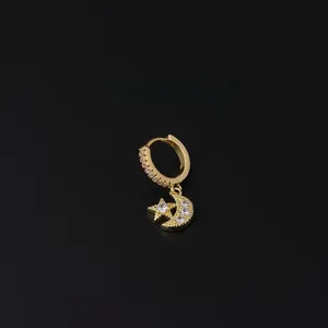 Macro view of gold hoop earring with star and moon charms micro-paved in zircon stones
