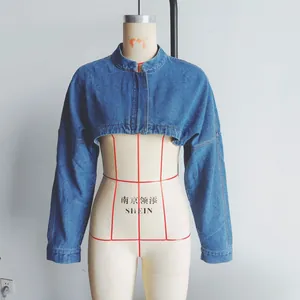 Front detail of deep blue cropped denim bolero jacket with round neck and zipper