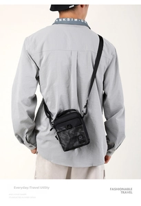 Dettaglio borsa uomo in nylon nero con motivo mimetico e tracolla regolabile pratica