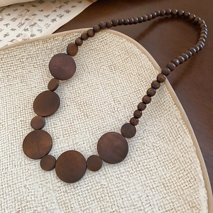 Vintage wooden bead necklace with geometric round pendants in a minimalist ethnic style