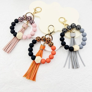 Detail of silicone bead wristlet keychains with leopard print, wooden hex bead and tassels