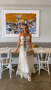 Detail of the cream-colored two-piece set with black bow ties and contrast edging