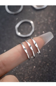 Macro shot of minimalist silver S925 ring featuring delicate engraved zodiac signs