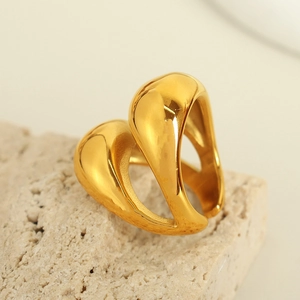 Abstract 18K gold plated sculptural double layer ring on a beige stone display
