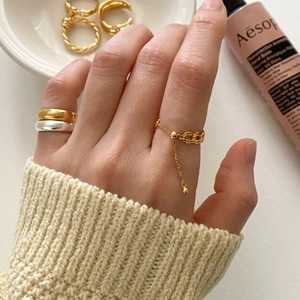 Detailed view of adjustable gold chain ring with smooth minimalist bands on hand