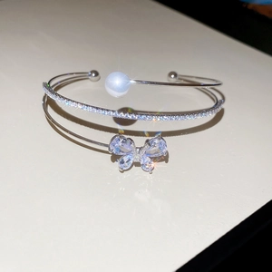 Detail of silver bangle with zircon butterfly, pearls, and sparkling double-layer design