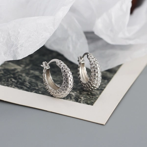 Macro shot of silver S925 sterling silver hoop earrings with unique bubble texture finish