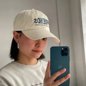 Detail of navy blue FRIENDS embroidery on cream twill cotton baseball cap