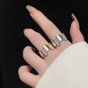 Detail of gold plated irregular stacked ring with zircon and shell inlay on finger