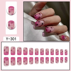 Pink gradient press-on nails with heart designs and full 24-piece set display