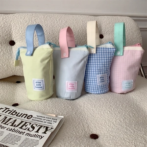 Detail of four colorful fabric pencil cases with convenient handles and zipper closure