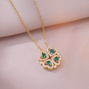 Détail du collier trèfle doré avec gemmes vertes et pétales en zircons brillants