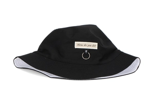 Detail of black bucket hat with 'How do you do?' patch, silver ring, and soft texture