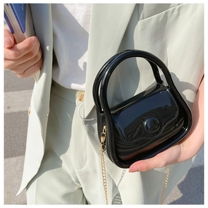 Mini glossy black jelly bag with gold chain strap shown on a model for daily styling