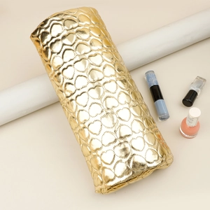 Detail of gold heart-quilted PU leather manicure arm rest with a shiny metallic finish