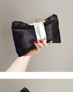 Detail der eleganten schwarzen Abendclutch mit Schleife, Satin-Finish und Goldverschluss