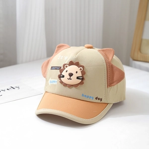 Détail de l'emblème lion 3D en silicone et oreilles sur casquette bébé beige