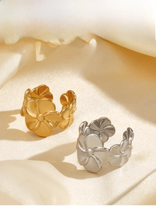 Detail of gold and silver vintage floral stainless steel open rings on silk fabric