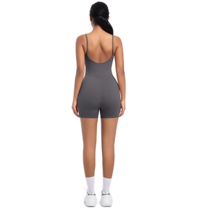 Detail view of charcoal grey open back yoga jumpsuit with thin straps and biker shorts style