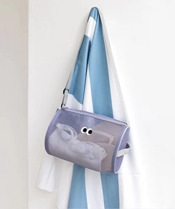 Close-up of purple mesh cylindrical wash bag with eye patterns hanging on a hook