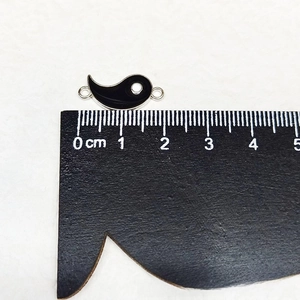 Macro shot of yin yang fish alloy pendant charm with double ring and measuring scale