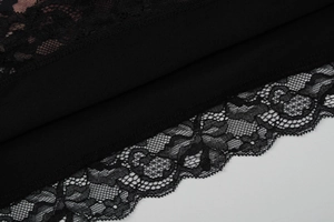 Detail shot of black plain weave fabric with delicate lace edge trim and fine stitching