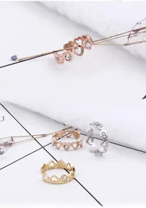 Détail de bagues ajourées en cœur avec zircon en finitions or, argent et or rose