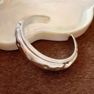 Irregular silver wave bangle with textured metallic finish for a modern artistic look