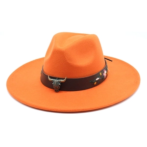 Detail of orange fedora hat featuring colorful floral embroidery and bronze bull head ornament
