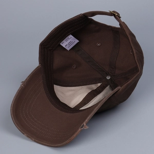 Detail view of cotton baseball cap interior with adjustable buckle and size label