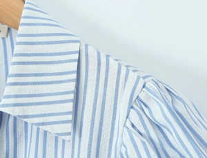 Detail of blue and white striped shirt collar and puffed sleeves on wooden hanger