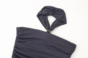 Détail d'une robe dos nu élégante avec tissu plissé gris foncé et boucle métallique