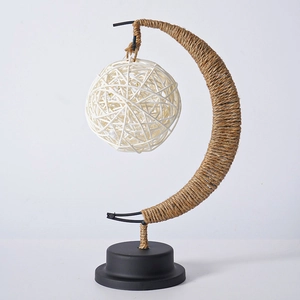 Detail of moon-shaped LED lamp featuring brown hemp rope wrap and white rattan ball shade