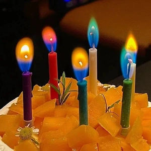 Colorful flame birthday candles burning on a fruit cake with vibrant rainbow fire effects