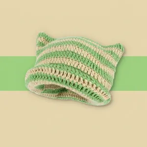 Detailed close-up of green and white striped crochet knit hat with cute cat ears