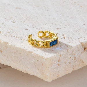 925 silver gold chain ring with blue rectangular gemstone on a textured stone