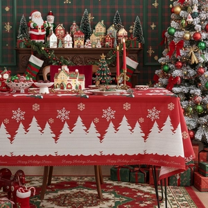 Dettaglio tovaglia natalizia con testo Happy Holidays e motivi di alberi e fiocchi