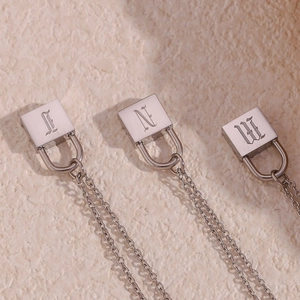 Macro shot of silver stainless steel gothic letter engraving on square lock pendants