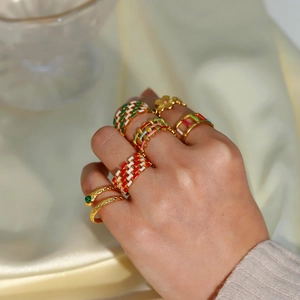 Detail of 18K gold plated stackable rings with colorful enamel drip oil designs