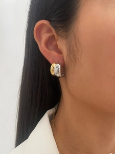 Detailed view of bicolor drop earrings on model showcasing gold and silver metallic luster