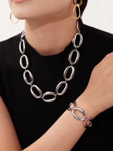 Close-up of polished silver geometry link chain necklace and bracelet set for women