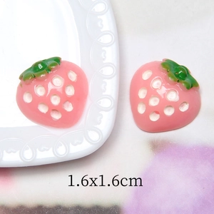 Makroaufnahme von 1,6x1,6 cm großen rosa Erdbeer-Anhängern aus Harz für DIY-Schmuck