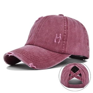 Close-up of distressed burgundy ponytail baseball cap with criss-cross back design